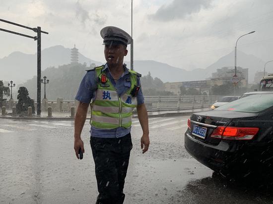 风雨中,交警大队一中队辅警周佳鹏冒雨执勤.文成公安供图