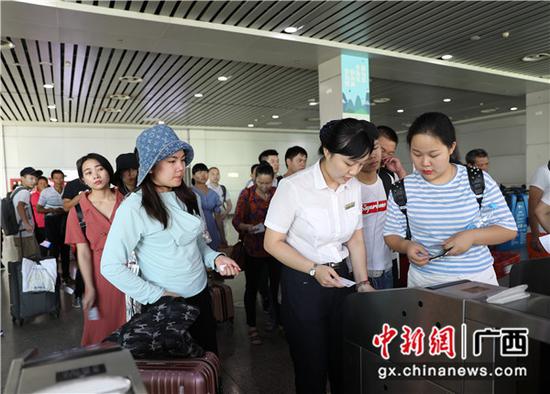 桂林火车站工作人员组织旅客有序检票进站。郑长贤 摄