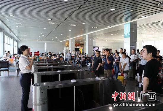 桂林火车站工作人员正在进行列车检票事项宣传。郑长贤 摄