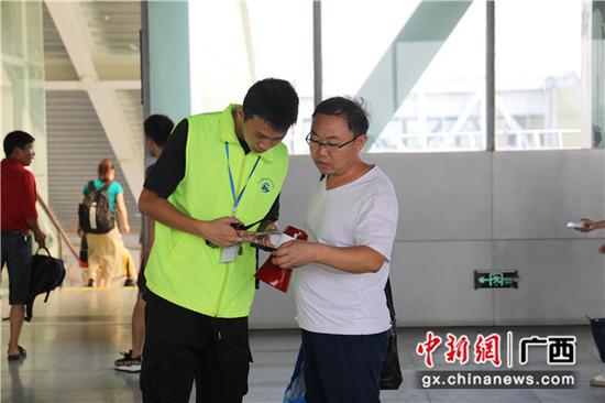 桂林火车站青年志愿者耐心解答旅客问询。常国思 摄
