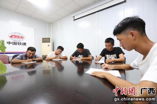 图为新员工在写信 。中铁二十五局供图