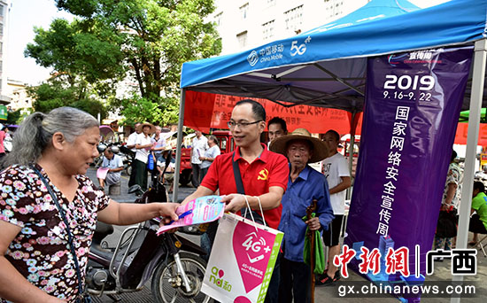 图为桂林移动党员志愿者向群众发放宣传资料。