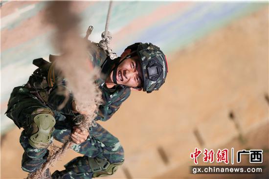 一名特战队员在进行抓绳攀登课目演示。 一名特战队员在进行抓绳攀登课目演示。