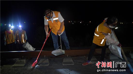为铁路职工正在清扫打磨车留下的碎渣、铁屑等。伍光钦 摄 为铁路职工正在清扫打磨车留下的碎渣、铁屑等。伍光钦 摄