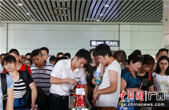 桂林火车站工作人员耐心引导旅客使用闸机检票进站。 李洪锐 摄 桂林火车站工作人员耐心引导旅客使用闸机检票进站。 李洪锐 摄
