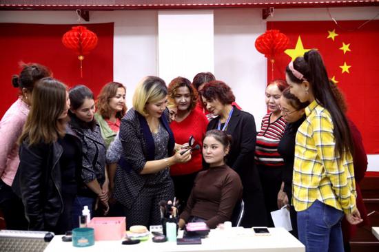 在且末县加哈巴格社区里，美容美发店的老板正在为社区的23名妇女培训美容美发的相关知识。热孜万古丽  摄