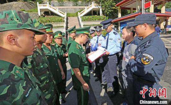 图为中国警方29日上午在广西凭祥友谊关零公里处,将越南籍毒贩黄明通移交越南警方。刘康 摄 图为中国警方29日上午在广西凭祥友谊关零公里处,将越南籍毒贩黄明通移交越南警方。刘康 摄