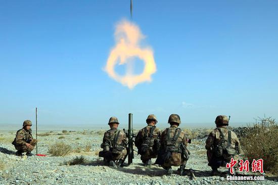 近日，新疆军区某边防团组织官兵在野外陌生地域展开迫击炮实弹射击考核，提高官兵野外条件下作战能力。图为炮弹出膛瞬间，空中出现火焰圈。王军强 摄