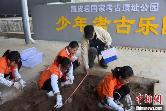 考古学家王仁湘现场指导青少年学生模拟考古实践。 孙自法 摄 考古学家王仁湘现场指导青少年学生模拟考古实践。 孙自法 摄