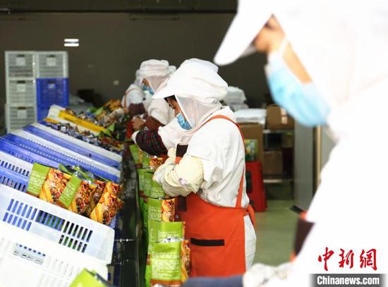 广西螺状元食品科技股份有限公司包装车间,工人正在包装螺蛳粉。 朱柳融 摄 广西螺状元食品科技股份有限公司包装车间,工人正在包装螺蛳粉。 朱柳融 摄