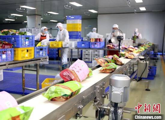 广西螺状元食品科技股份有限公司生产线,一袋袋包装好的螺蛳粉,通过传送带传送到打包车间。 朱柳融 摄 广西螺状元食品科技股份有限公司生产线,一袋袋包装好的螺蛳粉,通过传送带传送到打包车间。 朱柳融 摄