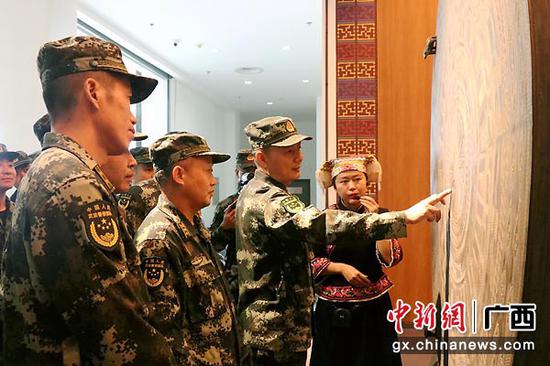 官兵询问铜鼓纹饰的含义。 官兵询问铜鼓纹饰的含义。