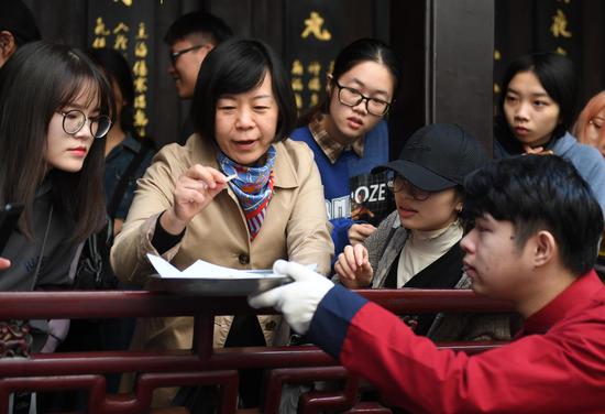 图为:市民端详中药切片.王刚摄