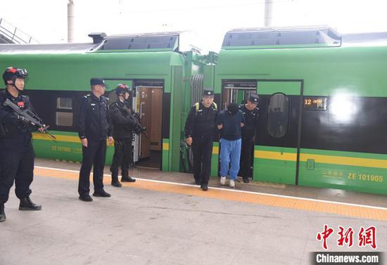 民警将电信诈骗犯罪嫌疑人带下火车。杨文涛 摄