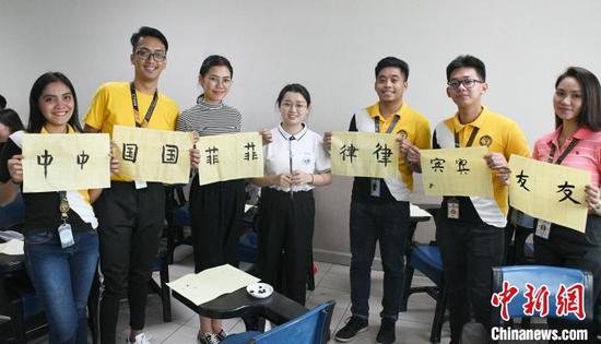 图片展作品之一,展示在菲的孔子学院教师教授菲律宾学生写汉字。主办方供图 图片展作品之一,展示在菲的孔子学院教师教授菲律宾学生写汉字。主办方供图