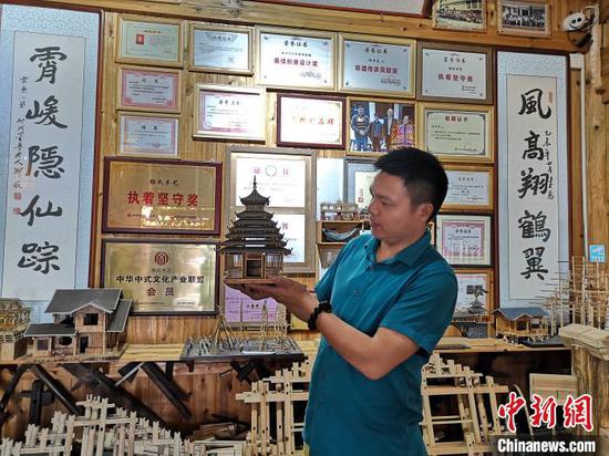杨云东展示侗族木构建筑模型。 林馨 摄 杨云东展示侗族木构建筑模型。 林馨 摄