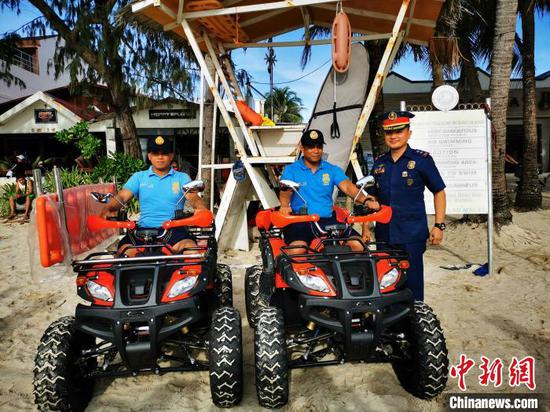 在阿克兰警察局局长PLTCOL JONATHAN PABLISO见证下,当地警察,首次驾驶鲜红车身、黑胶轮宽大、侧挂救护担架的沙滩救护摩托,组队巡逻。 关向东 摄