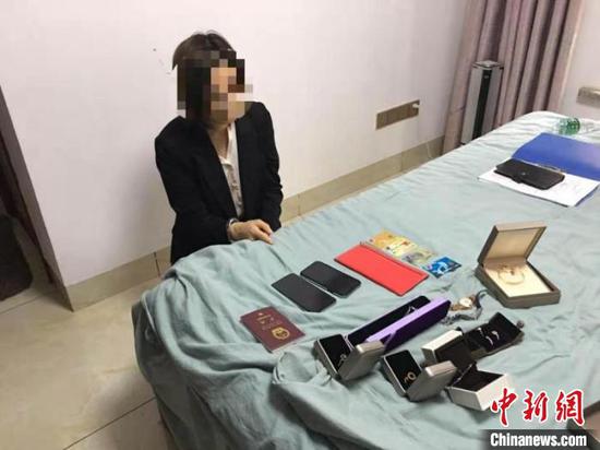 图为非法信贷公司“业务员”兼“财务”杨某指认涉案物品。 刘晓颖 摄 图为非法信贷公司“业务员”兼“财务”杨某指认涉案物品。 刘晓颖 摄