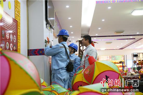 南方电网工作人员对靖西绣蕴坊绣球文化有限公司电路检修。陈伯鑫 摄 南方电网工作人员对靖西绣蕴坊绣球文化有限公司电路检修。陈伯鑫 摄
