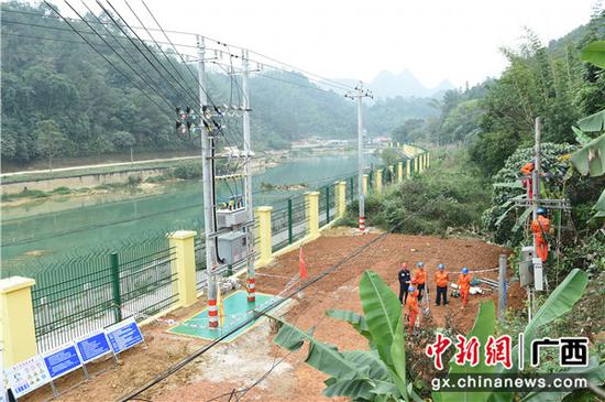 大新县硕龙镇归春河畔,施工人员正在拆除旧变压器,旁边的新变压器已经安装完成。陈海堂 摄 大新县硕龙镇归春河畔,施工人员正在拆除旧变压器,旁边的新变压器已经安装完成。陈海堂 摄