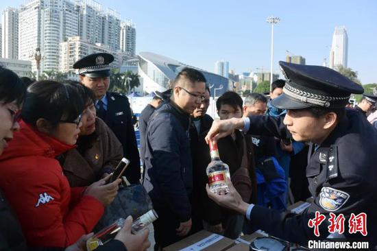 警方教民众辨认假冒伪劣五粮液。蒋雪林 摄 警方教民众辨认假冒伪劣五粮液。蒋雪林 摄