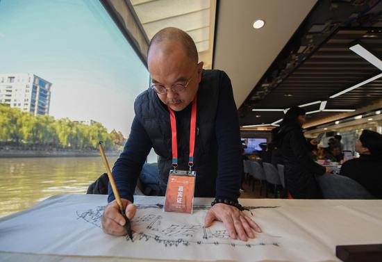 　　图为：大运河非遗民俗画项目代表人物及代表性传承人、中国民俗风情画家吴理人在大运河上进行美术创作。王刚 摄