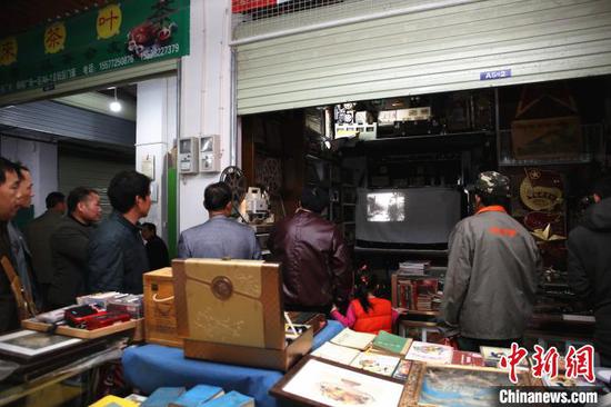 人们围在谢志宽的门店看电影。 朱柳融 摄 人们围在谢志宽的门店看电影。 朱柳融 摄