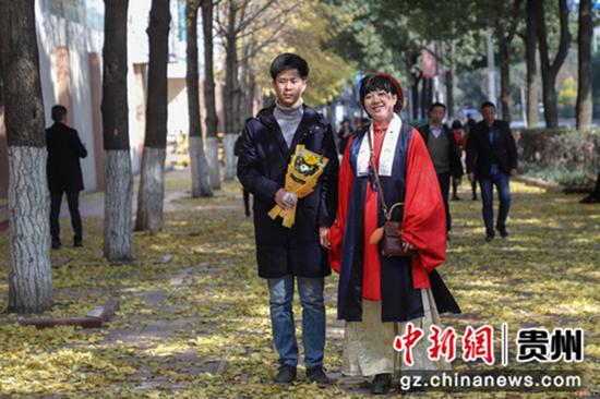 12月12日,一对情侣在银杏树下拍照。当日,贵州贵阳南明区遵义路街头金黄的银杏景色,引市民驻足观赏、拍照留念。
