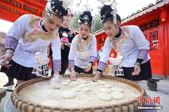12月13日,侗族民众包糍粑过侗年。当日是贵州省榕江县乐里七十二侗寨侗族民众欢庆侗族新年的日子。中新社记者 贺俊怡 摄 12月13日,侗族民众包糍粑过侗年。当日是贵州省榕江县乐里七十二侗寨侗族民众欢庆侗族新年的日子。中新社记者 贺俊怡 摄