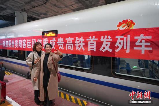 12月16日,两名乘客在贵阳北站站台与首发列车合影留念。当日,随着开往成都南的C6008次动车驶出贵阳北高铁站,标志着成都至贵阳高铁(简称成贵高铁)宜宾至贵阳段开通运营,成贵高铁全线通车,成都与贵阳两个省会城市最快2小时58分可达。成贵高铁起于四川省成都市,途经眉山市、乐山市、宜宾市,云南省昭通市威信县、镇雄县,以及贵州省毕节市,终至贵阳市。线路全长648公里,设计时速250公里。中新社记者 贺俊怡 摄 12月16日,两名乘客在贵阳北站站台与首发列车合影留念。当日,随着开往成都南的C6008次动车驶出贵阳北高铁站,标志着成都至贵阳高铁(简称成贵高铁)宜宾至贵阳段开通运营,成贵高铁全线通车,成都与贵阳两个省会城市最快2小时58分可达。成贵高铁起于四川省成都市,途经眉山市、乐山市、宜宾市,云南省昭通市威信县、镇雄县,以及贵州省毕节市,终至贵阳市。线路全长648公里,设计时速250公里。中新社记者 贺俊怡 摄