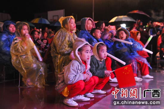 冒雨观看演出的当地民众 冒雨观看演出的当地民众