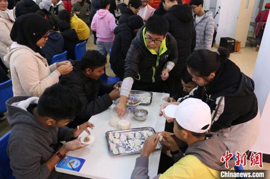 22日,马来西亚33名师生在柳州铁道职业技术学院包饺子,过冬至。 林馨 摄 22日,马来西亚33名师生在柳州铁道职业技术学院包饺子,过冬至。 林馨 摄