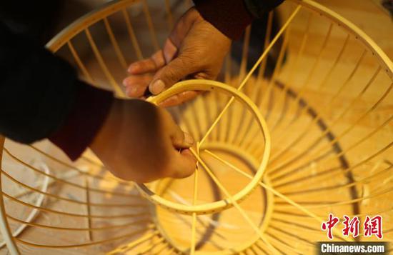 贵州省丹寨县龙泉镇卡拉村鸟笼工艺品手工坊，苗族村民在制作鸟笼灯具。　黄晓海 摄