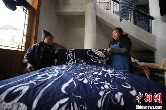 贵州丹寨宁航蜡染传承基地，工人在整理晾晒好的蜡染床单。　黄晓海 摄