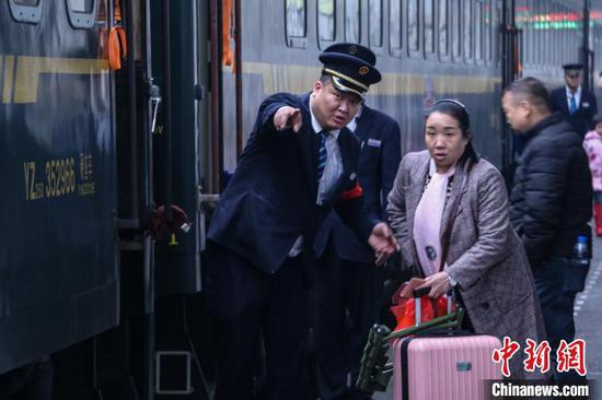 图为乘务员在帮助旅客。 王东铃 摄 图为乘务员在帮助旅客。 王东铃 摄