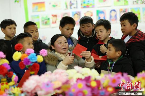 贵州丹寨金钟易地扶贫搬迁安置区“4点半学堂”,志愿者在教孩子们做新年贺卡。 黄晓海 摄 贵州丹寨金钟易地扶贫搬迁安置区“4点半学堂”,志愿者在教孩子们做新年贺卡。 黄晓海 摄