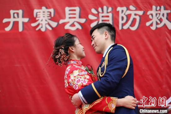 新郎與新娘在集體婚禮上相互擁抱慶賀。 黃曉海 攝