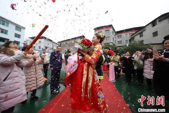一身救援裝束打扮的新郎在集體婚禮上用救援中常用的“抱式救人”把自己的新娘帶上舞臺。 黃曉海 攝