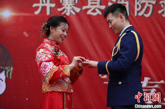 新郎與新娘在集體婚禮上相互交換結婚戒指。 黃曉海 攝