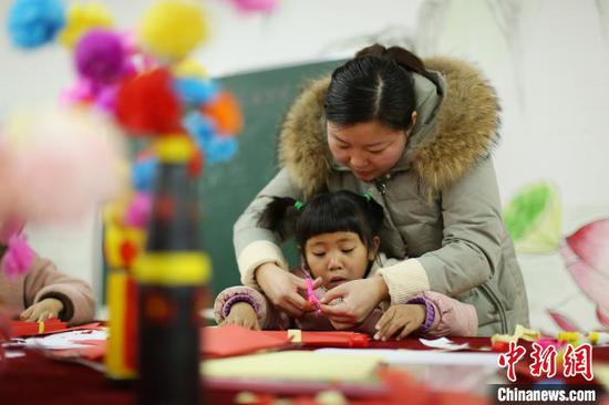 贵州丹寨金钟易地扶贫搬迁安置区“4点半学堂”,志愿者在教一名小孩子做新年贺卡。 黄晓海 摄 贵州丹寨金钟易地扶贫搬迁安置区“4点半学堂”,志愿者在教一名小孩子做新年贺卡。 黄晓海 摄