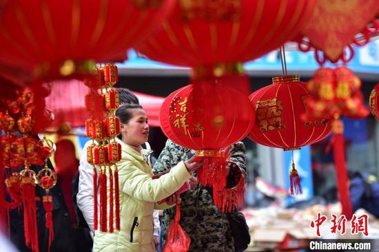 图为村民在集市上选购灯笼、春联等商品。 杨武魁 摄 图为村民在集市上选购灯笼、春联等商品。 杨武魁 摄