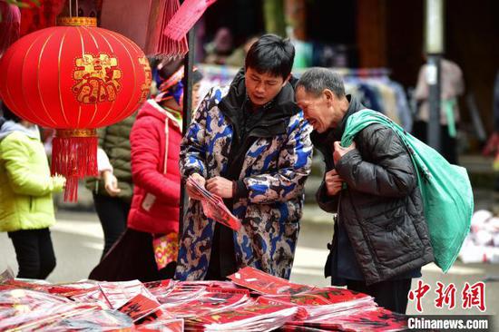 图为集市上商家在给顾客介绍商品。 杨武魁 摄 图为集市上商家在给顾客介绍商品。 杨武魁 摄