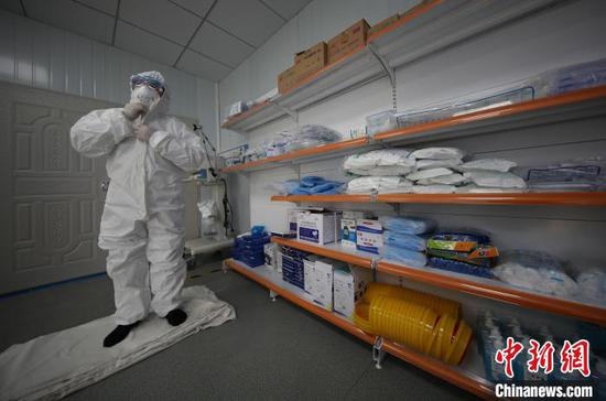 图为李斌在穿防护服准备到隔离病房巡诊。 黄晓海 摄 图为李斌在穿防护服准备到隔离病房巡诊。 黄晓海 摄