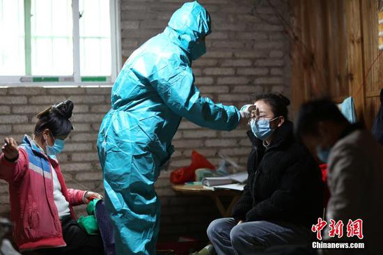 图为1月31日,肖世军为返乡村民测量体温。 中新社发 黄晓海 摄 图为1月31日,肖世军为返乡村民测量体温。 中新社发 黄晓海 摄
