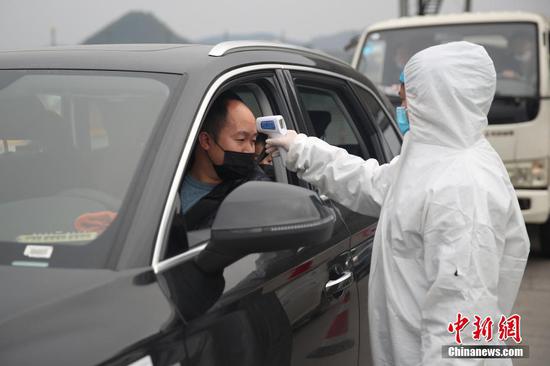 1月31日，在厦蓉高速贵阳东收费站出口，工作人员正在对车辆上的乘客进行体温检测，以防控新型冠状病毒感染的肺炎疫情。中新社记者 瞿宏伦 摄