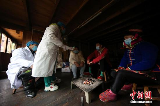 图为在贵州丹寨排调镇党早村宰飞自然寨,肖世军(左一)、潘启兰(左二)在村民家中进行体温监测。 黄晓海 摄 图为在贵州丹寨排调镇党早村宰飞自然寨,肖世军(左一)、潘启兰(左二)在村民家中进行体温监测。 黄晓海 摄