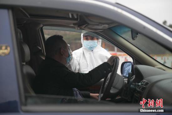 1月31日,在厦蓉高速贵阳东收费站出口,工作人员正在对车辆上的乘客进行体温检测,以防控新型冠状病毒感染的肺炎疫情。中新社记者 瞿宏伦 摄 1月31日,在厦蓉高速贵阳东收费站出口,工作人员正在对车辆上的乘客进行体温检测,以防控新型冠状病毒感染的肺炎疫情。中新社记者 瞿宏伦 摄