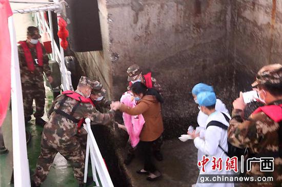 图为海警人员顺利将幼儿接到舰艇。刘寒丰 摄 图为海警人员顺利将幼儿接到舰艇。刘寒丰 摄