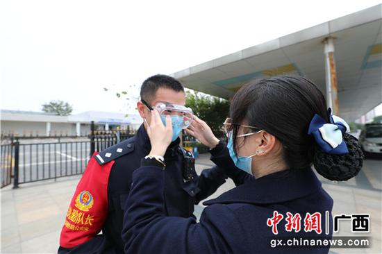 1月30日，年初六，警嫂黄华诗在结婚周年纪念日这天为准备上班的丈夫胡扬易戴上防护目镜，叮嘱他注意安全。 陈大鹏 摄