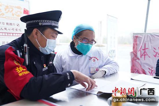 图为黄贵国核对发热旅客信息。